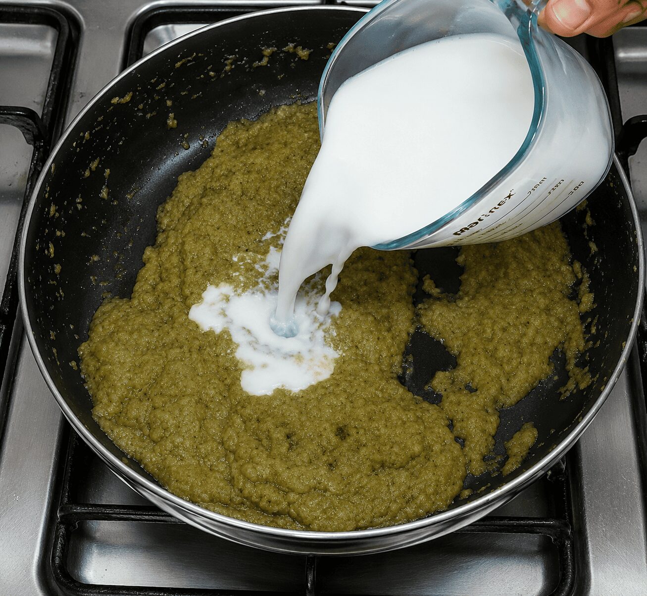 Adding room-temperature milk to the Anda Malai Curry gravy