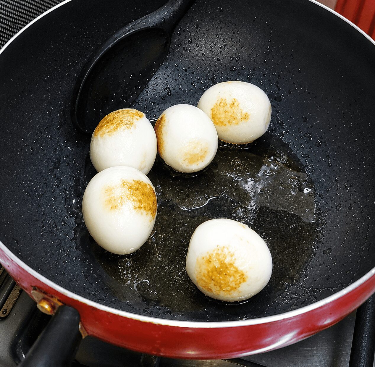 Scored boiled eggs frying lightly golden for Egg White Korma