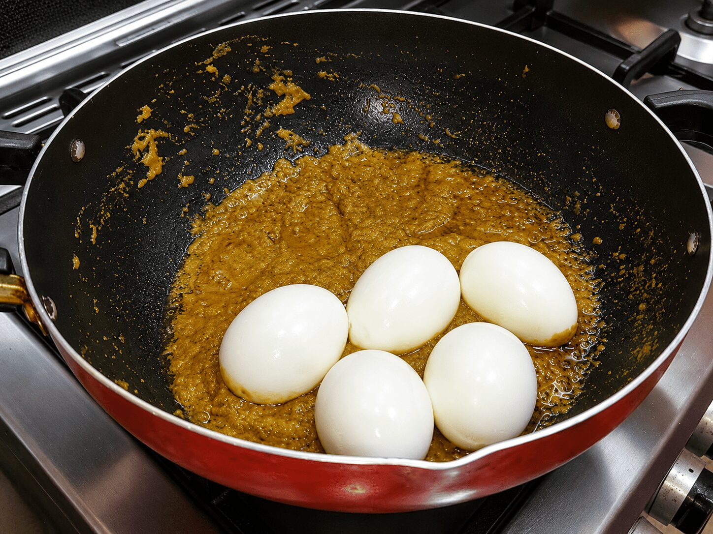 Adding scored, half-boiled eggs to the silky gravy, Reshmi Anda Curry