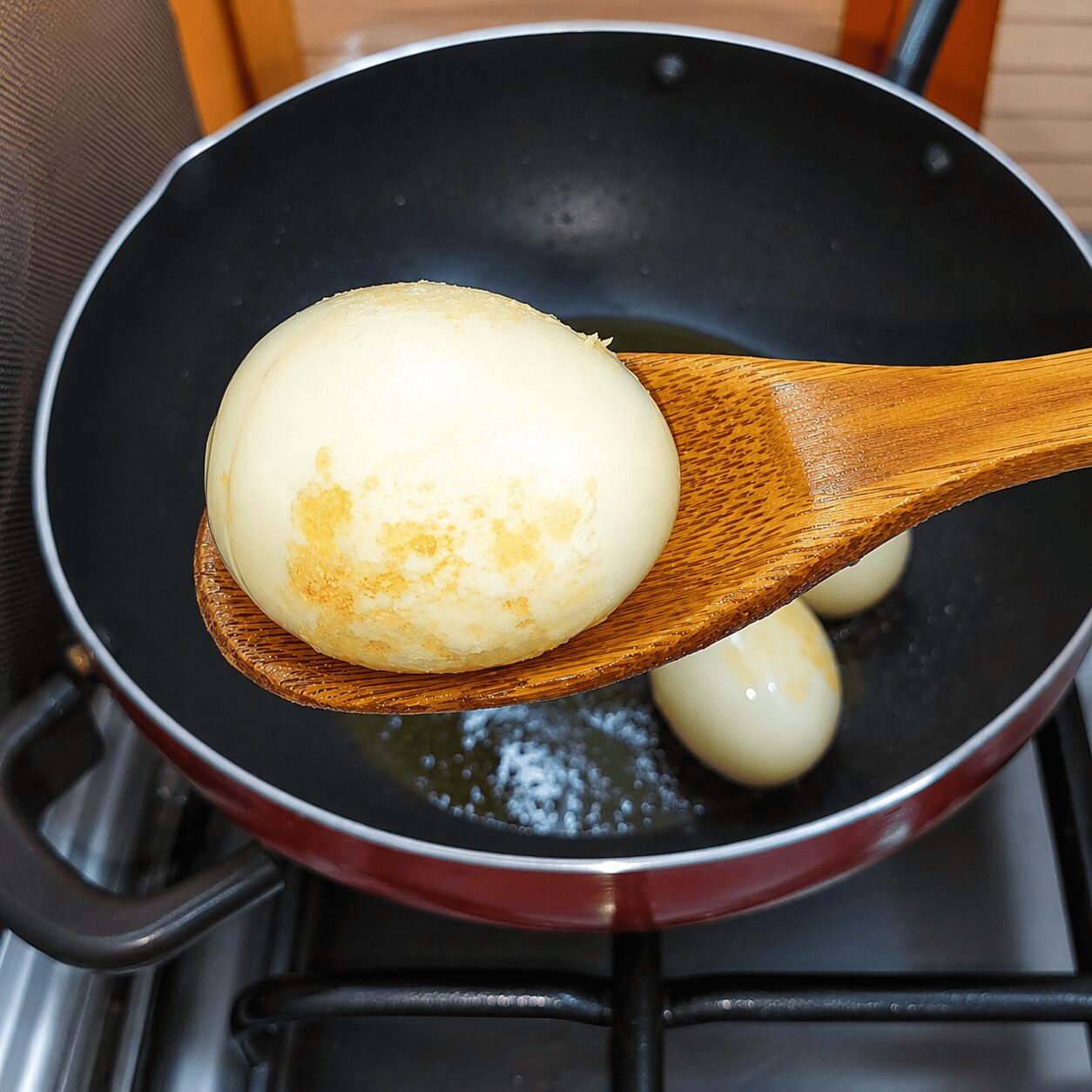 Boiled eggs frying until crispy golden skin for Anda Aloo Salan