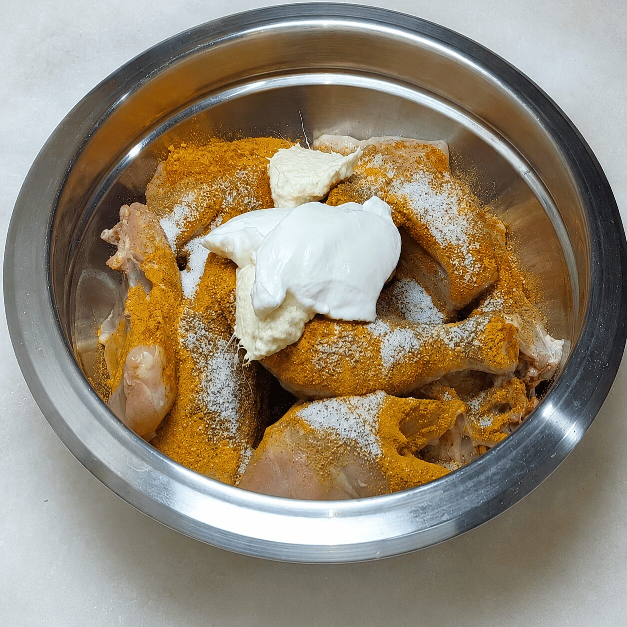 Chicken marinating with yogurt, garlic-ginger paste, and spices for Chicken Dark Bunglow