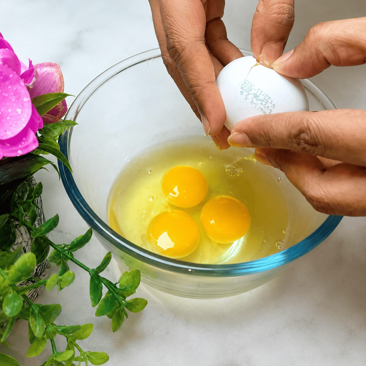 Cracking eggs into a bowl one at a time for Butter Garlic Egg