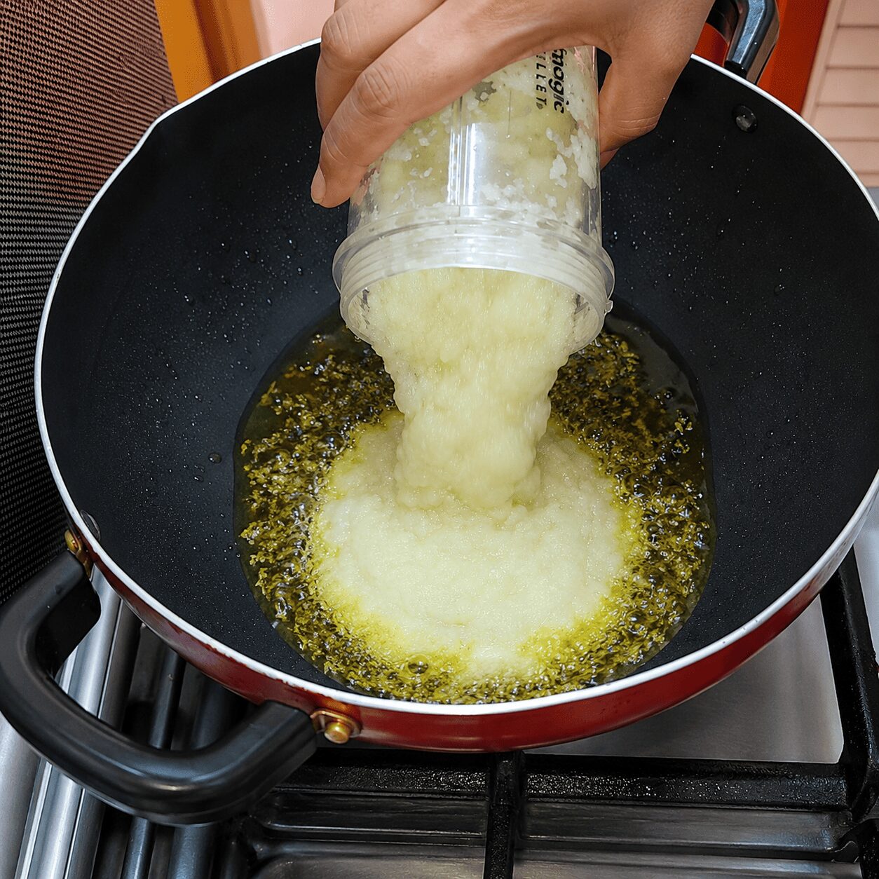 Cumin spluttering and blended onion paste added to the pan for Anda Aloo Salan
