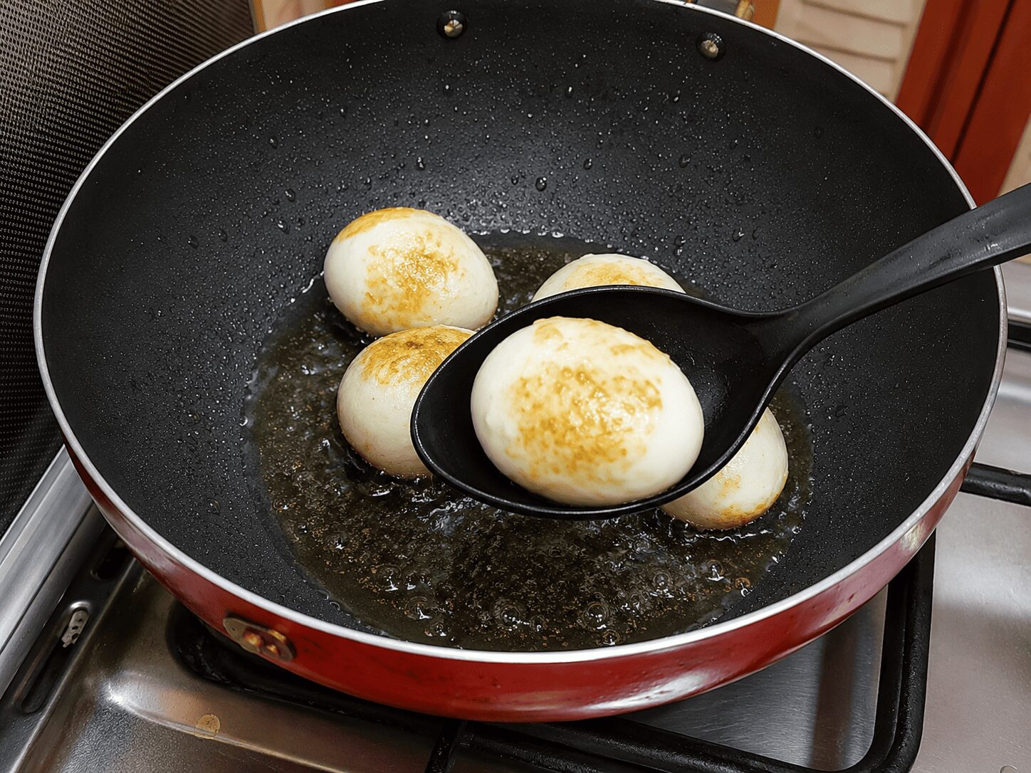 Frying scored eggs golden for Mughlai Shahi Egg Curry