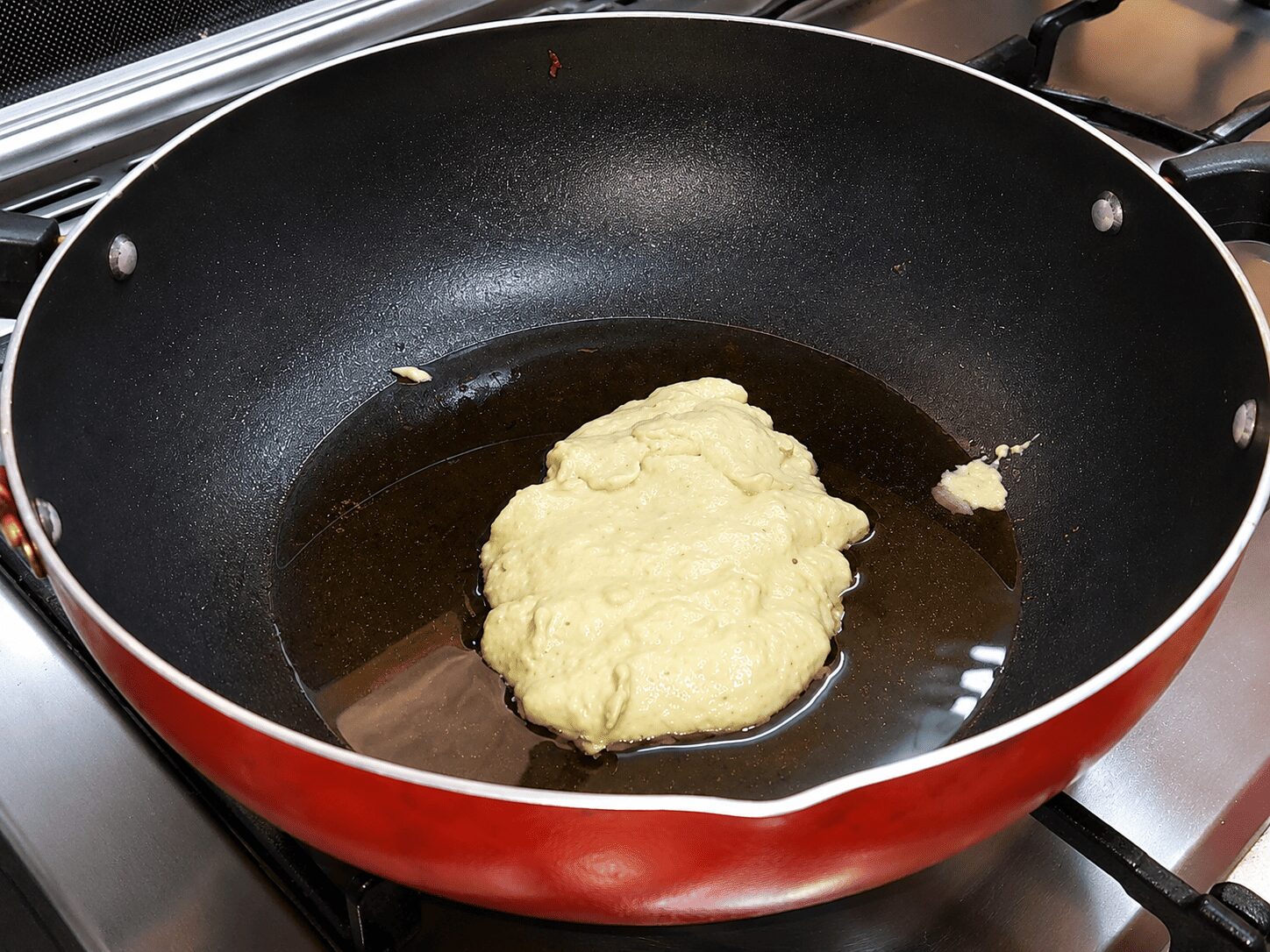 Light green onion-cashew paste frying in oil for Reshmi Anda Curry