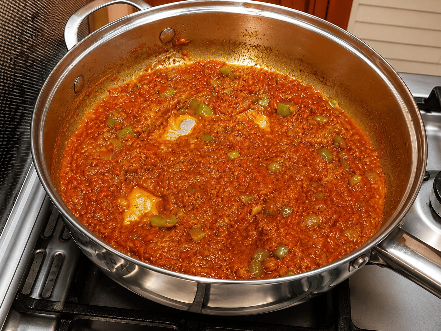 Making wells in the gravy before adding eggs, Egg Shakshuka