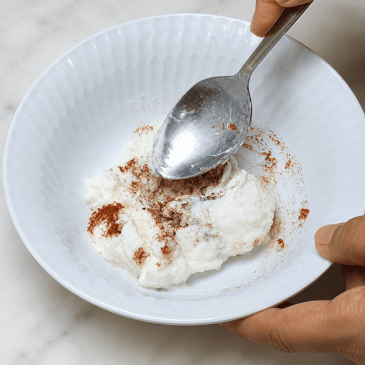Mixing thick yogurt with garlic, salt, and paprika for Turkish Eggs Çılbır