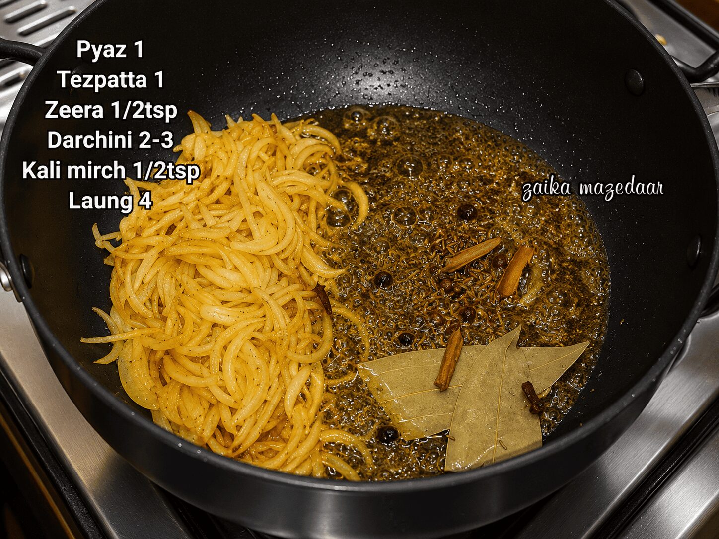 Onion frying to a deep golden brown with whole spices for biryani base
