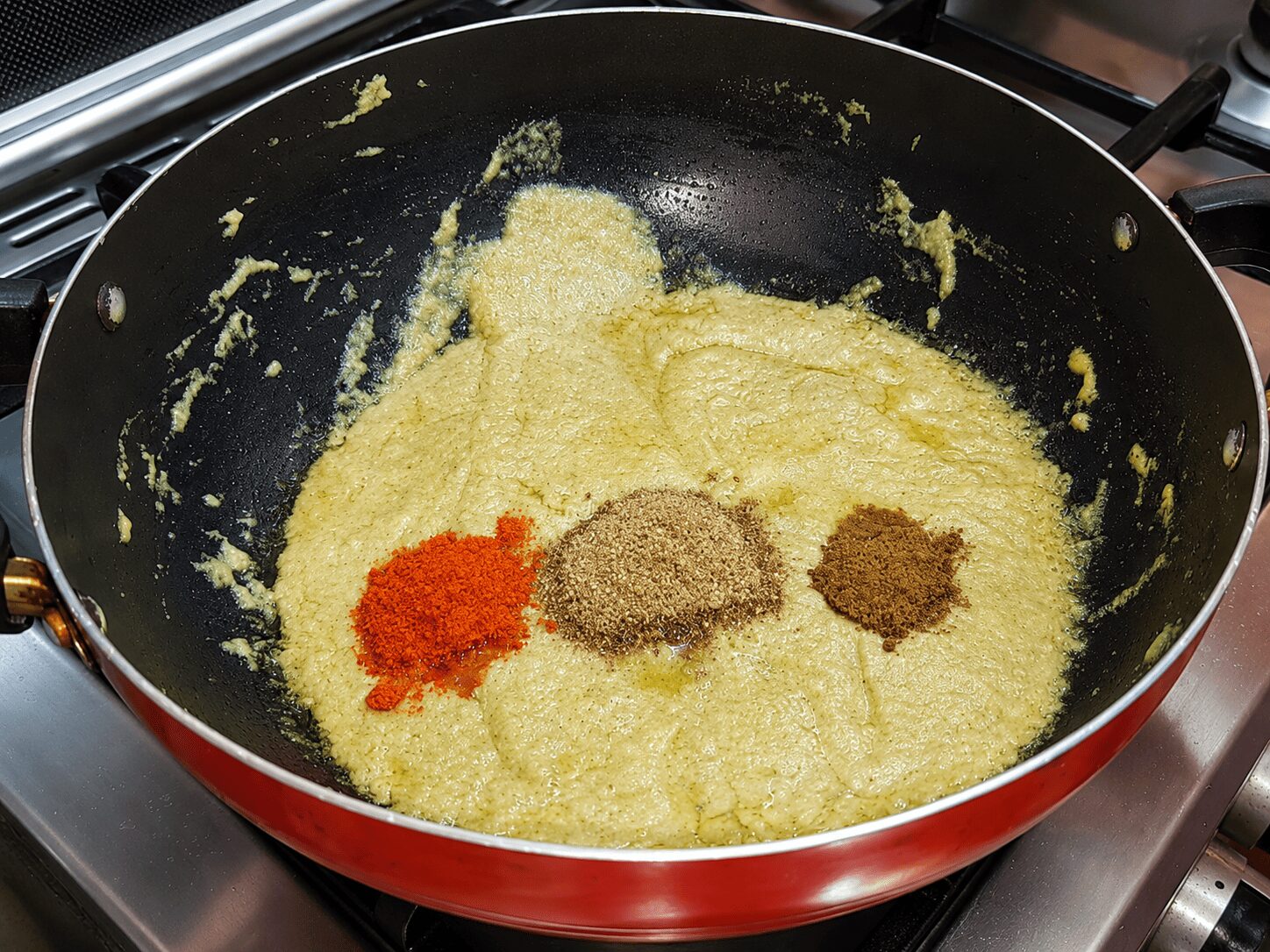 Roasting dry spices into the onion-cashew paste for Reshmi Anda Curry