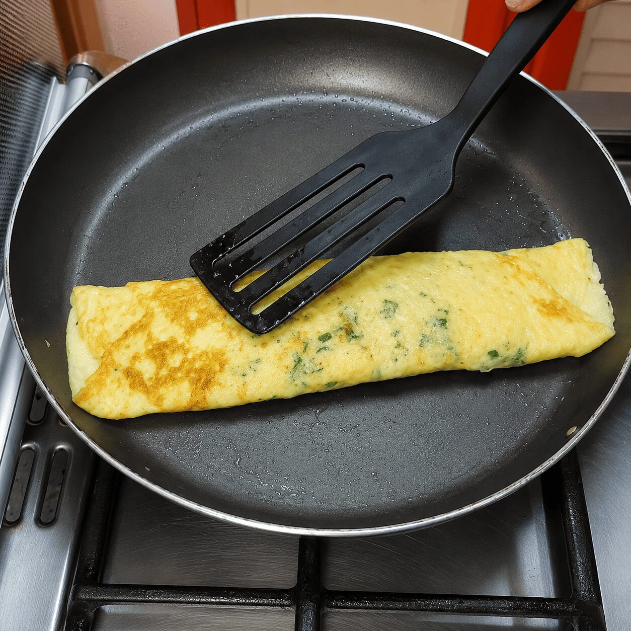 Rolling the half-cooked omelette into a log for Egg Kebab Curry