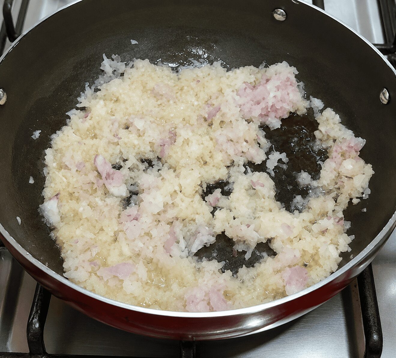 Sautéing grated onion in oil and butter for Anda Ghotala