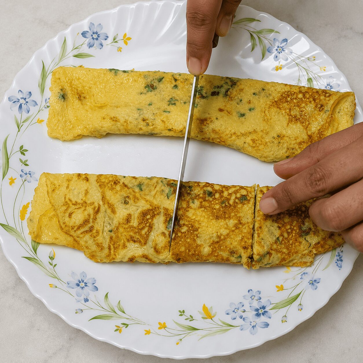 Slicing the rolled omelette into kebab rounds for Egg Kebab Curry