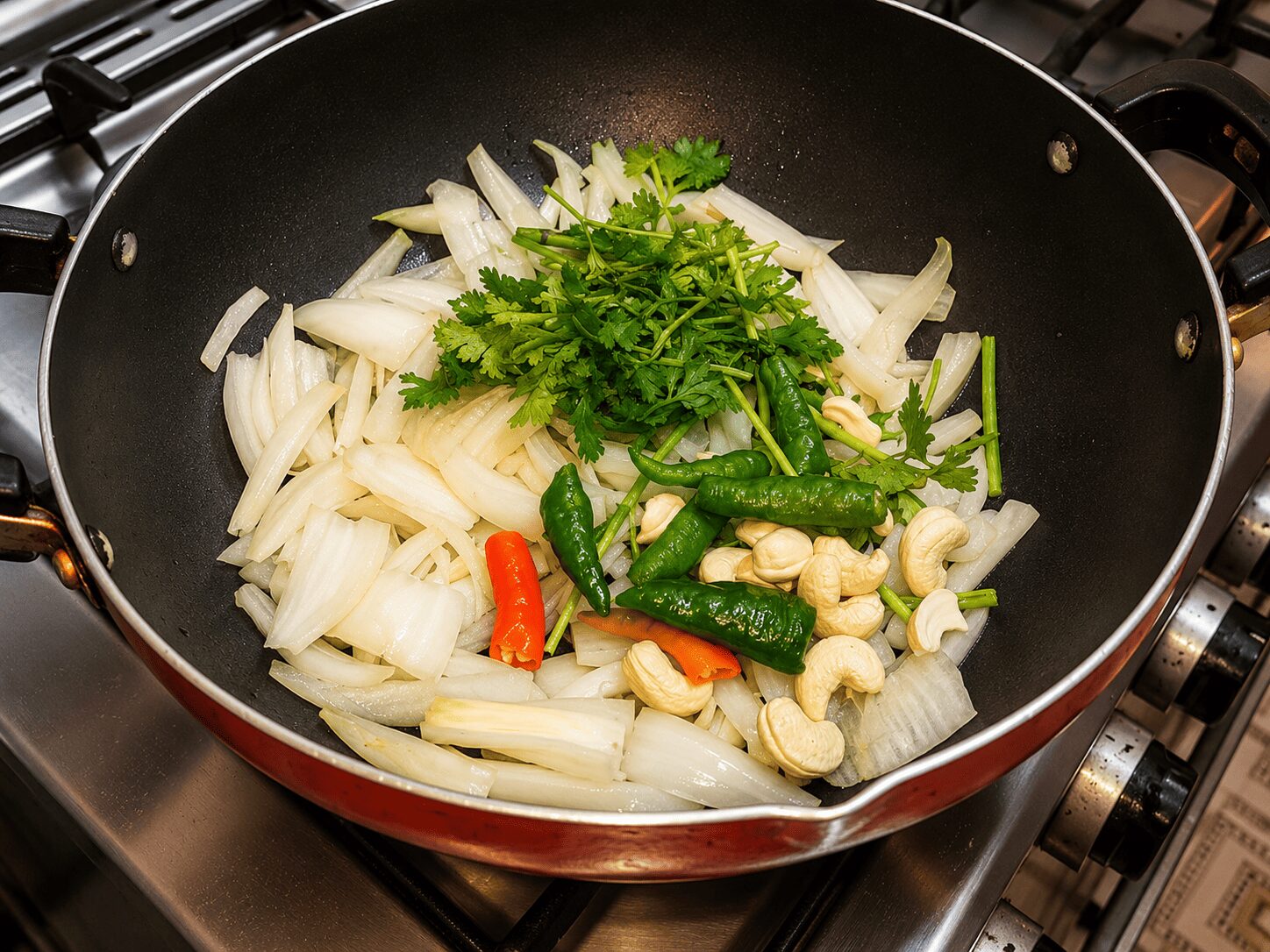 Softening onion, cashews, and coriander stems together for Reshmi Anda Curry