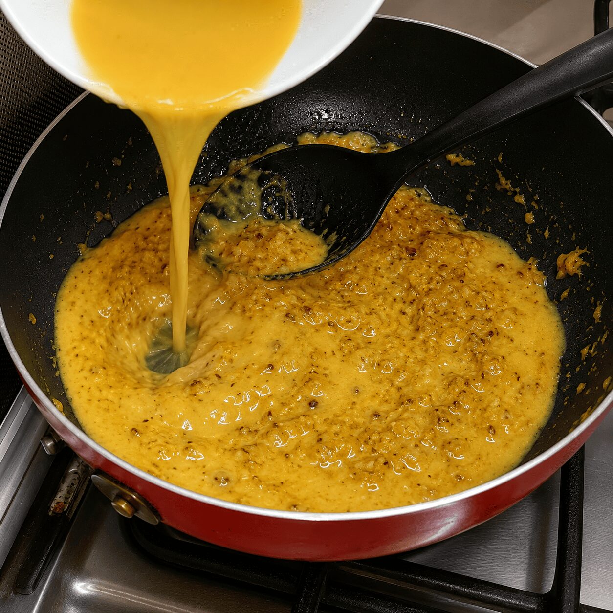 Stirring the cashew-sesame paste into the roasted Mughlai Shahi Egg Curry masala