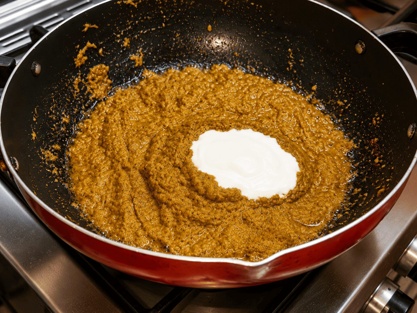 Whisking room-temperature yogurt into the masala for Reshmi Anda Curry