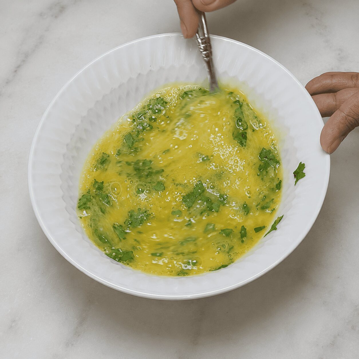 Whisking the omelette mixture with milk for Egg Kebab Curry
